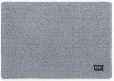 A grey bath mat with a black JOOP! logo in the bottom right corner.