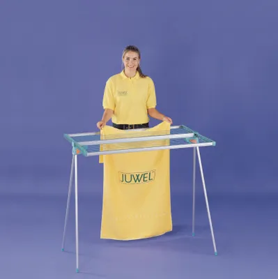 A woman is holding a yellow towel with the brand name 'JUWEL' on it, in front of a drying rack.
