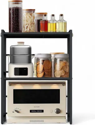 A three-tiered kitchen shelf unit with various items on each shelf, including jars of food, bottles of oil, a food steamer, and a microwave oven.
