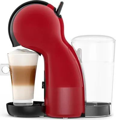 A red coffee machine with a glass of layered coffee next to it, and a water reservoir.