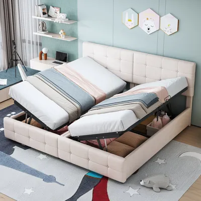 A bedroom scene with a bed that has storage compartments open, revealing bedding and pillows. There is a desk and shelves in the background.