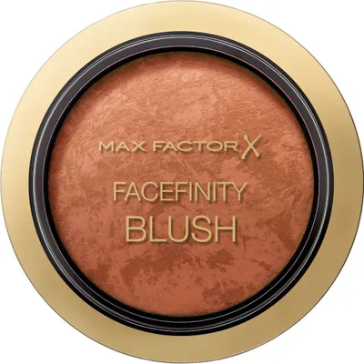 A close-up, top-down view of a round compact of blush with a gold-colored rim.