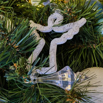 A close-up view of a Christmas tree ornament hanging on a branch.