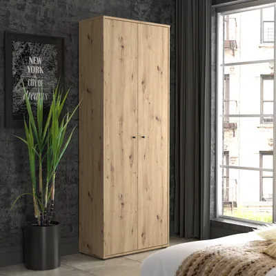 A tall, two-door wardrobe with a wood-grain finish stands in a room with a large window and a plant.