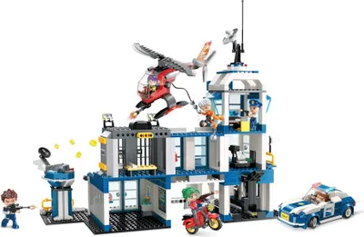 A Lego-style police station playset with figures, a helicopter, a car, and a motorcycle, set against a white background.