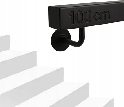 A black metal handrail with "100 cm" embossed on it, mounted on a white wall above white stairs.