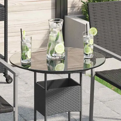 A round glass tabletop with two glasses of iced drinks and a pitcher of iced drinks on a patio.