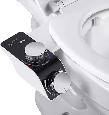 A close-up view of a bidet attachment for a toilet seat, showing the control panel with knobs and indicators.