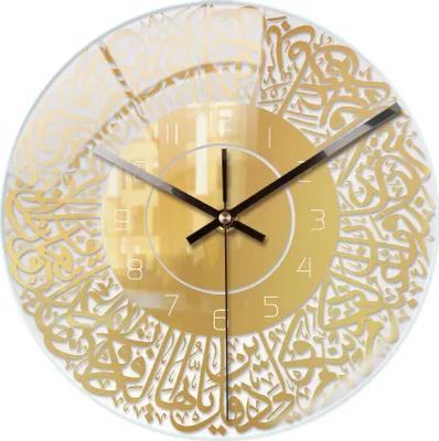 A close-up view of a transparent wall clock with gold Arabic calligraphy.