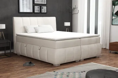 A bedroom scene with a large boxspring bed as the main focus.