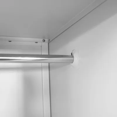 Close-up inside view of a locker or cabinet, showing a metal hanging rod and its supports.