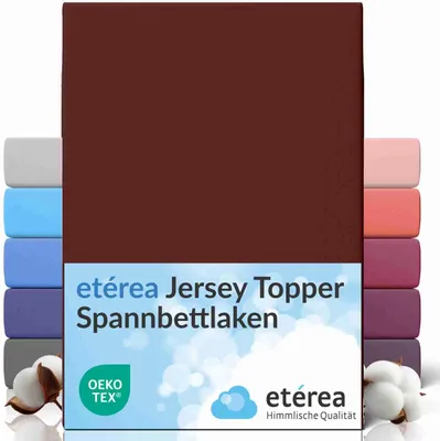 A product image showing a burgundy fitted sheet, with other colored sheets stacked behind it, and cotton bolls in the foreground.