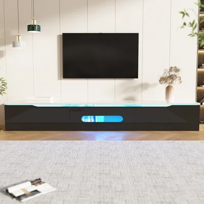 A modern living room setup with a TV mounted on the wall above a sleek, black TV stand with LED lighting.