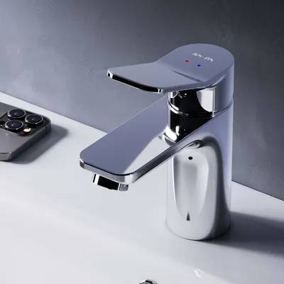 A chrome faucet is shown on a white sink with a smartphone in the background.