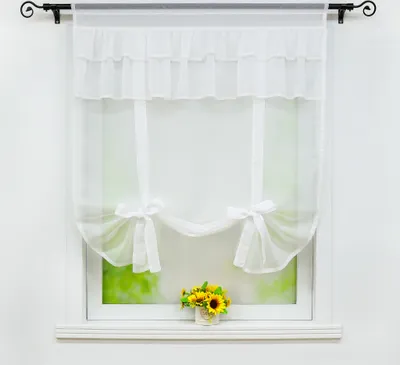 A white sheer curtain with ruffled top and tie-backs is shown hanging on a window. A small vase of sunflowers sits on the windowsill below.
