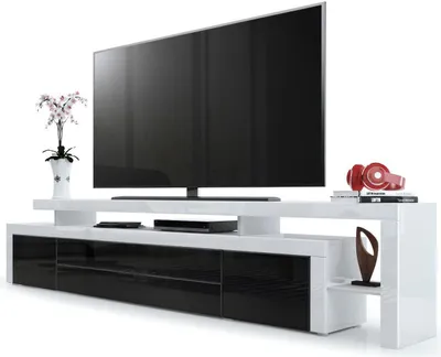 A modern TV stand with a large flat-screen television on top, along with decorative items.