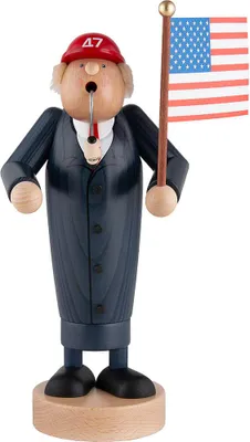 A wooden figurine of a man in a suit holding an American flag and a pipe.