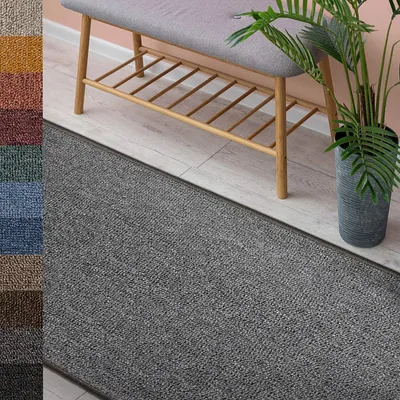 A gray runner rug in front of a bench and a potted plant.
