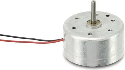 A small, silver DC motor with a metal shaft and two wires (black and red) attached. The motor is shown against a plain white background.
