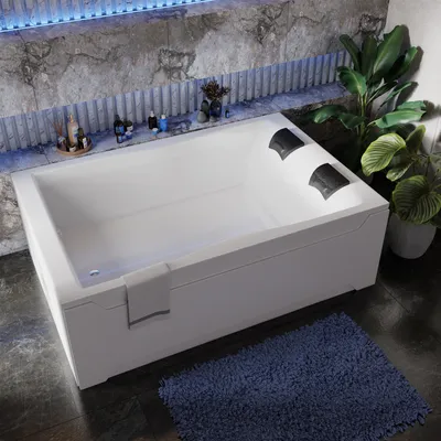 A modern white bathtub with black headrests is shown in a bathroom setting with marble-like walls and a blue rug.