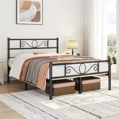 A metal bed frame with a headboard and footboard, set up in a bedroom with bedding and storage baskets underneath.