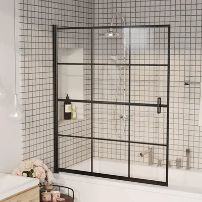 A modern bathroom with a black framed shower screen over a bathtub.