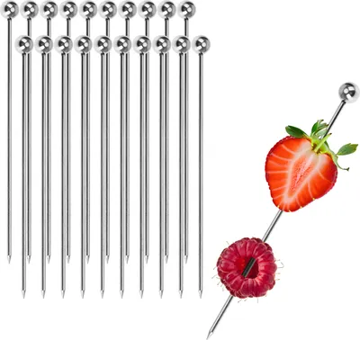 A group of stainless steel cocktail skewers are lined up on the left side of the image, while a single skewer with a strawberry and raspberry is shown on the right.