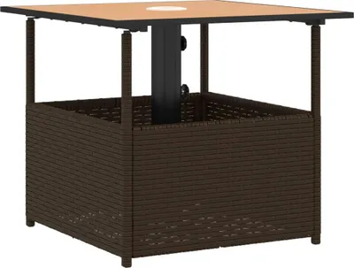 A square outdoor table with a woven base and a tan top, featuring a central hole for an umbrella.