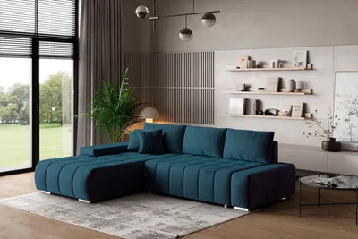 A modern living room with a large sectional sofa, shelves with decor, and a large window.