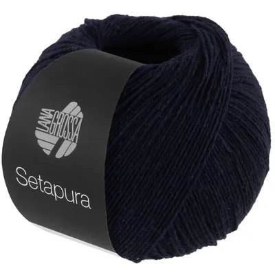 A ball of dark blue yarn with a black label wrapped around it.