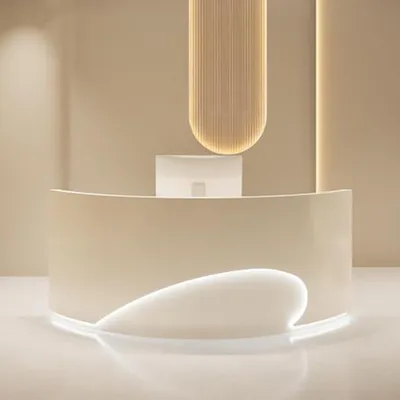 A modern reception desk with curved lines and integrated lighting, set against a neutral background.