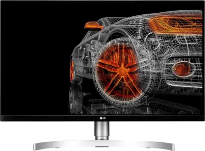 A wireframe rendering of a car on a black background, displayed on a monitor.