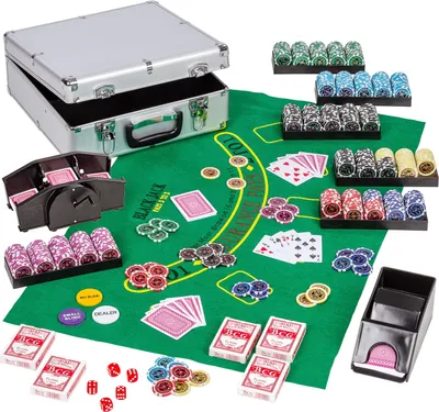 A poker set laid out on a green felt mat, including a silver carrying case, poker chips, playing cards, and dice.