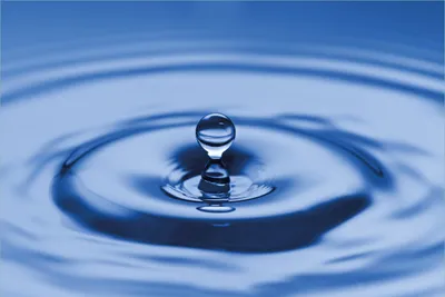 Produktbild von Wallario Premium Vliestapete Fototapete Wassertropfen im blauen Wasser in der Größe 400 x 267 cm, extra dick, wird in 5 Teilen geliefert