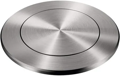 A close-up, studio shot of a round, brushed metal object with concentric circles.