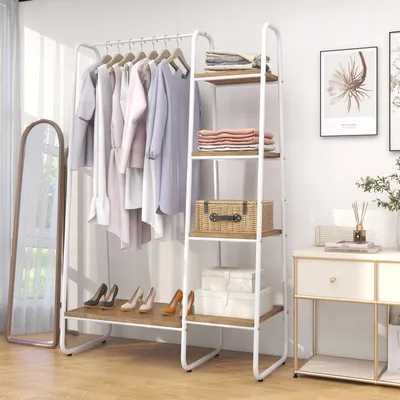 A white metal and wood garment rack with clothes hanging on it and shelves for storage, next to a full-length mirror and a small cabinet.