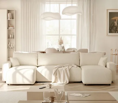 A modern living room with a large sectional sofa, coffee table, and dining area in the background.