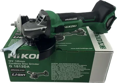 A cordless disc grinder is placed on top of its packaging box.