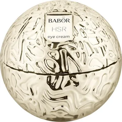 A round, textured gold container for eye cream, with a label on top.
