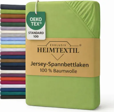 A stack of folded sheets in various colors is shown next to a single green sheet, which is the main focus. The green sheet has a tag attached and is partially wrapped in a cardboard band with product information.
