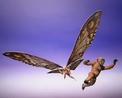 Two action figures, a moth-like creature and a monkey-like creature, are depicted in mid-air against a purple and pink gradient background.