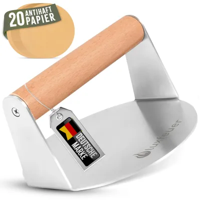 A stainless steel burger press with a wooden handle and a tag showing the German flag and "Deutsche Marke" (German Brand). A stack of round parchment papers is visible in the background.