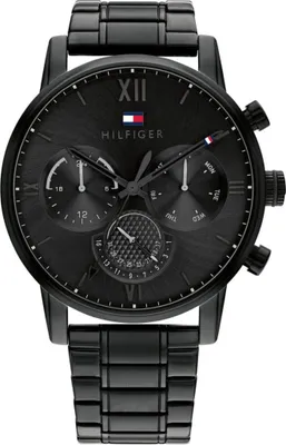A black Tommy Hilfiger watch with a metal band, shown from the front against a white background.