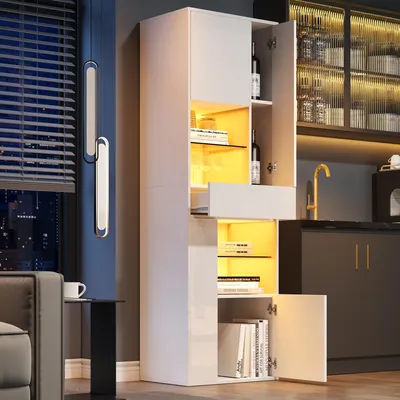 A modern living room or kitchen setting with a tall, white, high-gloss cabinet illuminated by warm LED lights.