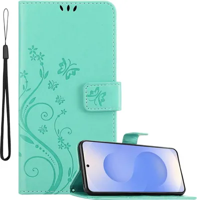 A turquoise flip phone case with a floral butterfly design is shown open, with a smartphone placed inside and angled for display. A black wrist strap is attached to the left side of the case.