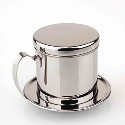 A stainless steel Vietnamese coffee filter with a lid and saucer, presented against a white background.