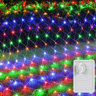 A net of colorful LED lights is draped over bushes and grass, suggesting outdoor decoration.