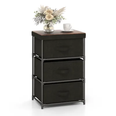 A three-drawer fabric dresser with a wooden top, a vase of flowers, and a cup of coffee on top.