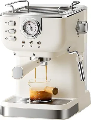A cream-colored espresso machine is shown in a studio setting, with espresso brewing into a small glass beaker.