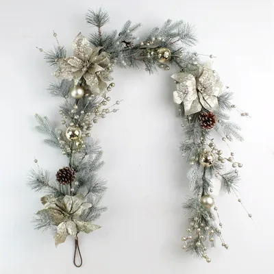 A festive Christmas garland decorated with poinsettias, pine cones, and baubles, draped against a white background.